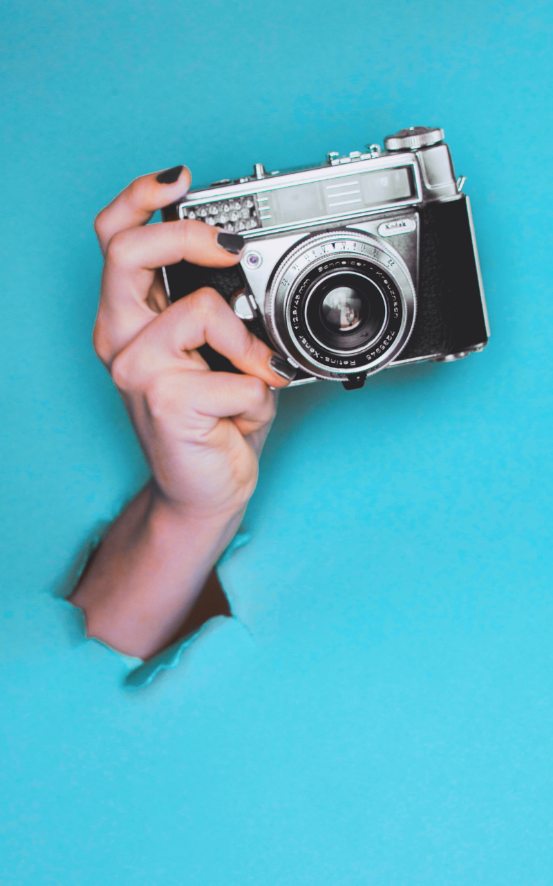 mano sujetando una cámara de fotos