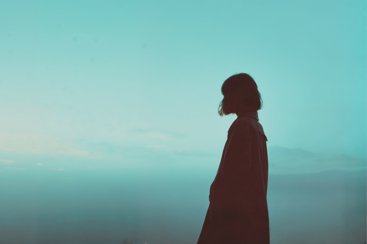 Silueta de mujer en un fondo de cielo turquesa